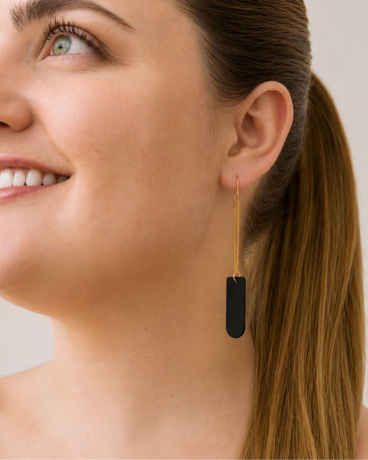 The Leah black and gold pull-through earrings shown on model — Olivia Holland