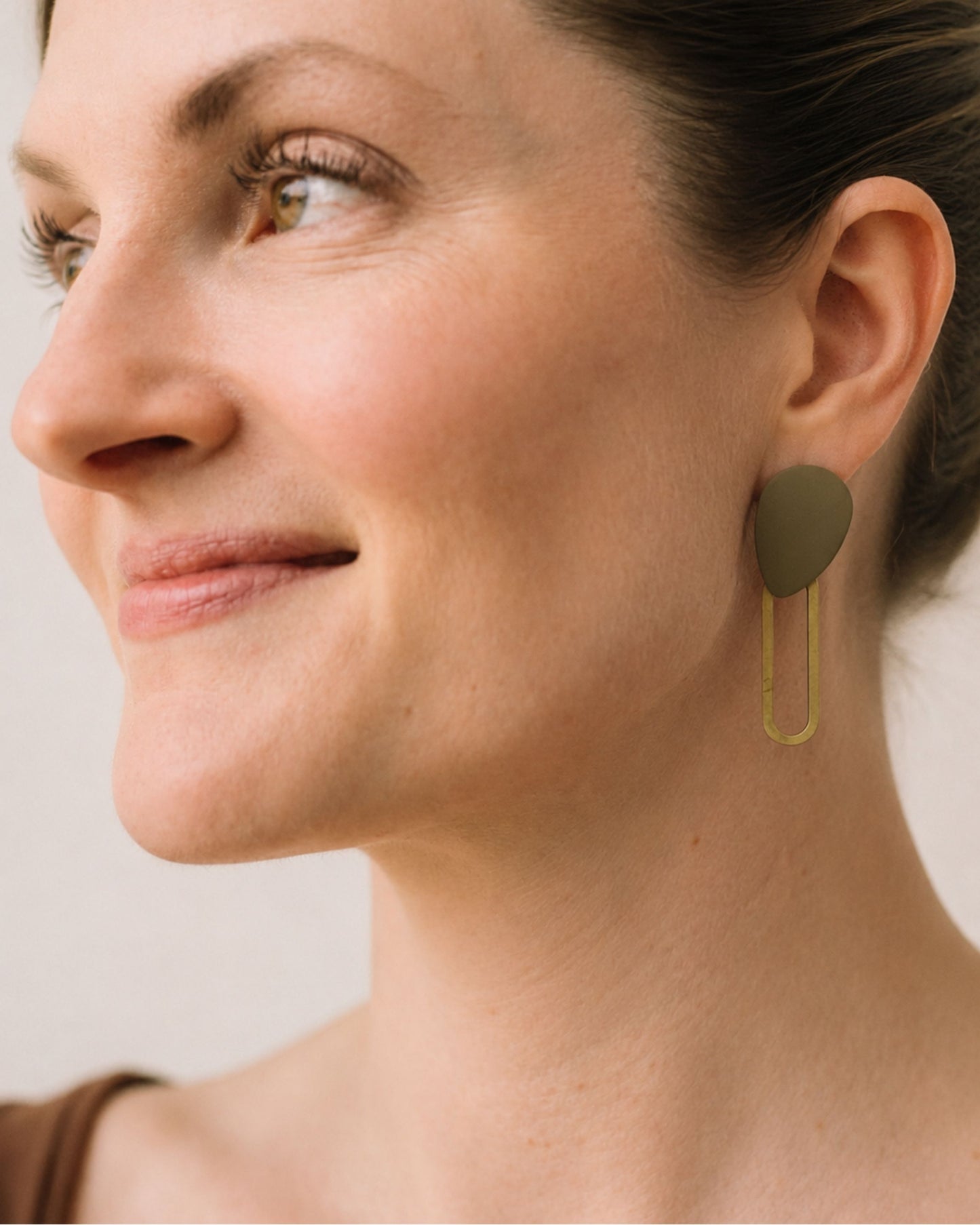The Mack textured green and gold stud earrings shown on model — Olivia Holland