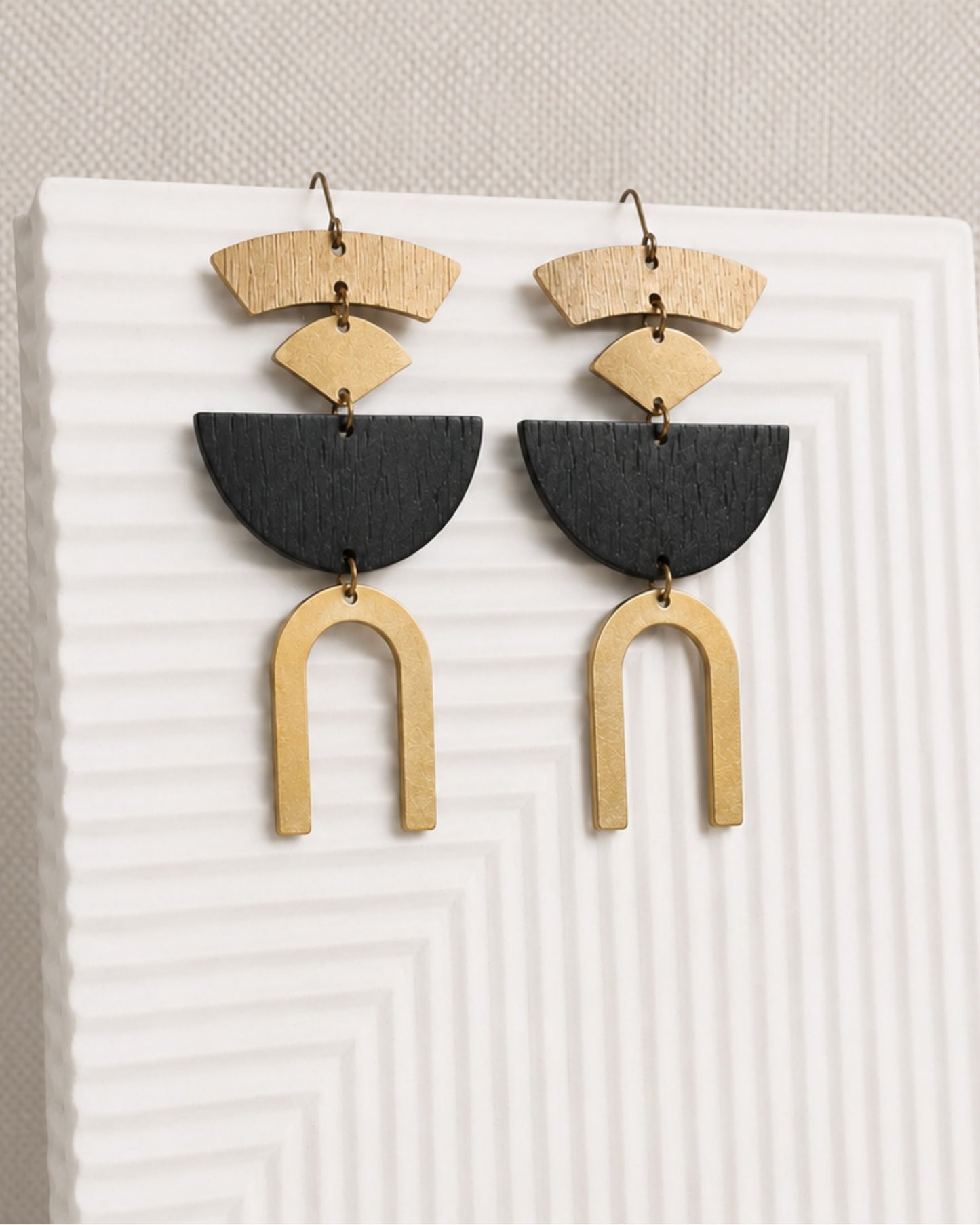 Styled close-up of The Rosa gold and black half moon statement earrings — Olivia Holland